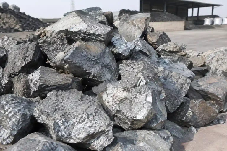 Ferrosilicon lumps with metallic gray fractured surfaces inrd an industrial stockya